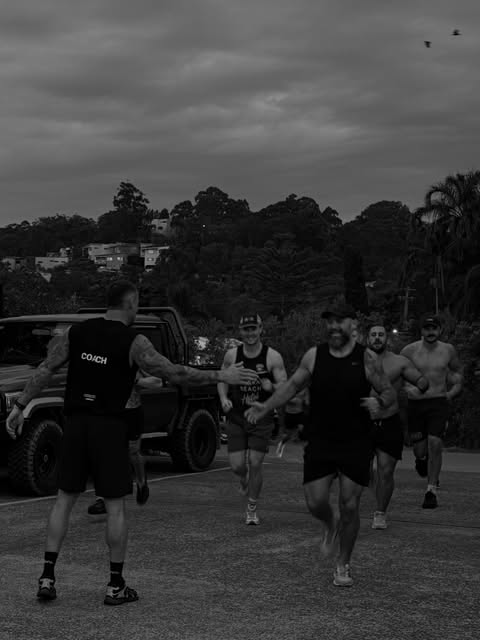 Outdoor group training run with coach high-fiving members